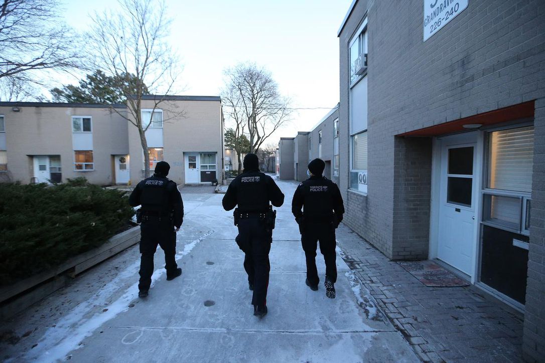 Three Toronto police officers walking in townhouse community