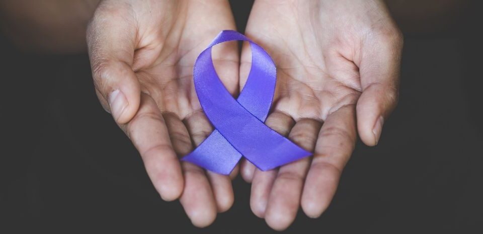 two hands holding purple ribbon for awareness of domestic violence e ribbon
