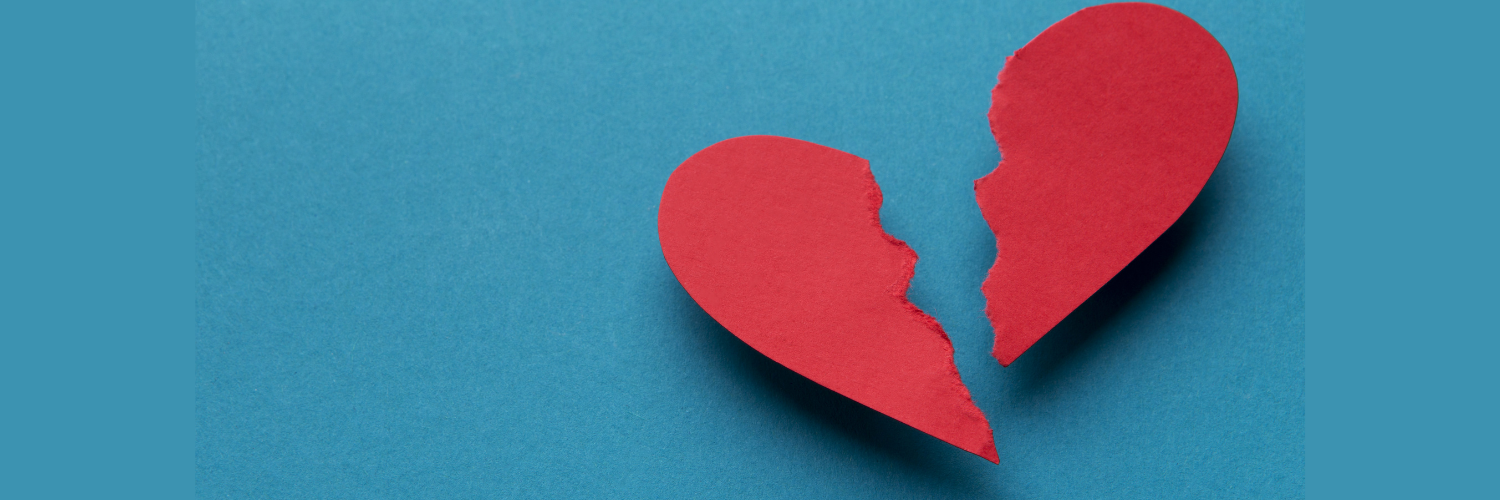 Red paper heard torn in half with a blue background