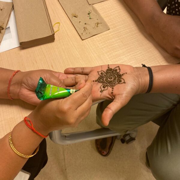 Henna Tattoo station at the Jane Street Hub Annual BBQ 2023; hand with henna tattoo of a mandala