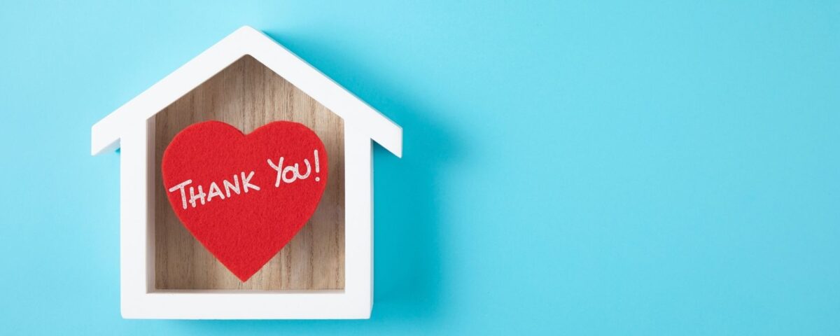 "Thank You!" heart shaped note inside a house silhouette on a blue background