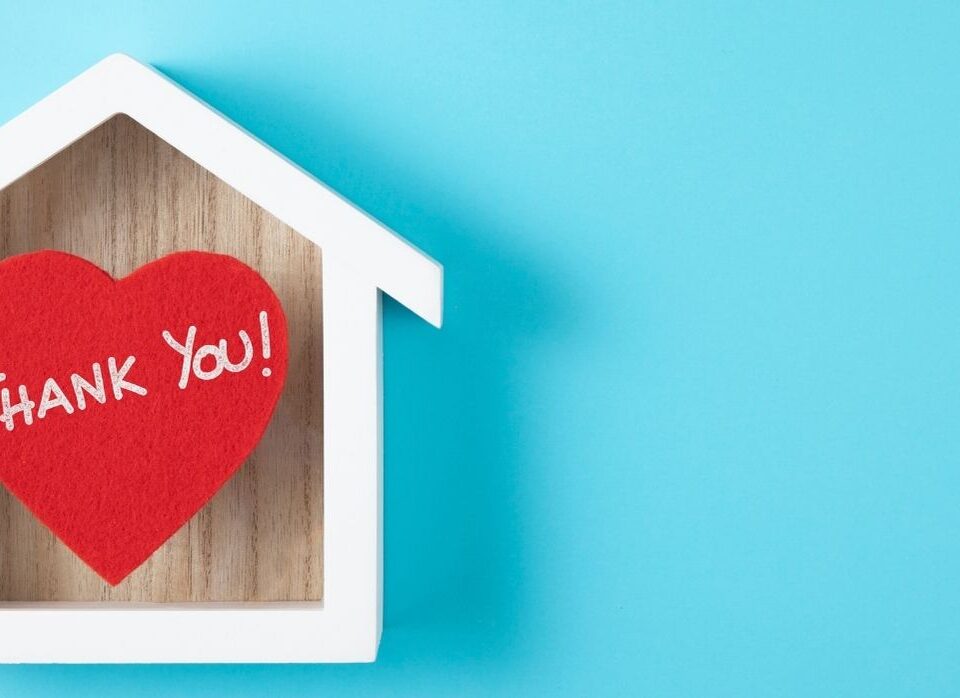 "Thank You!" heart shaped note inside a house silhouette on a blue background