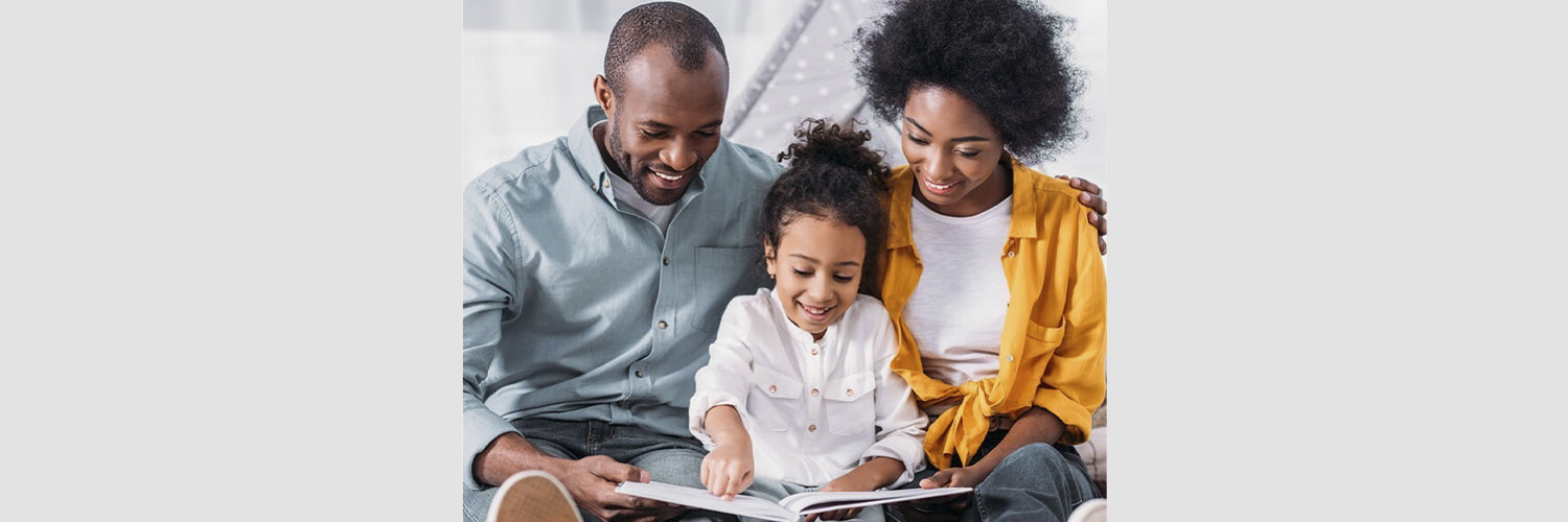 father and mother read book with little girl