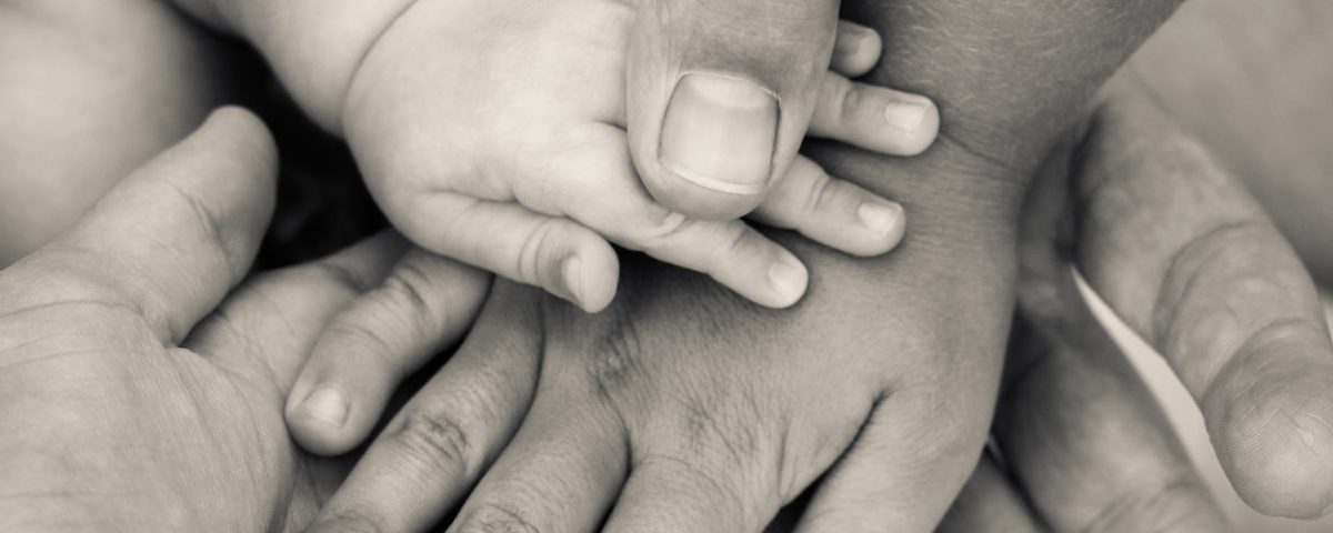 infant hand on parent hands