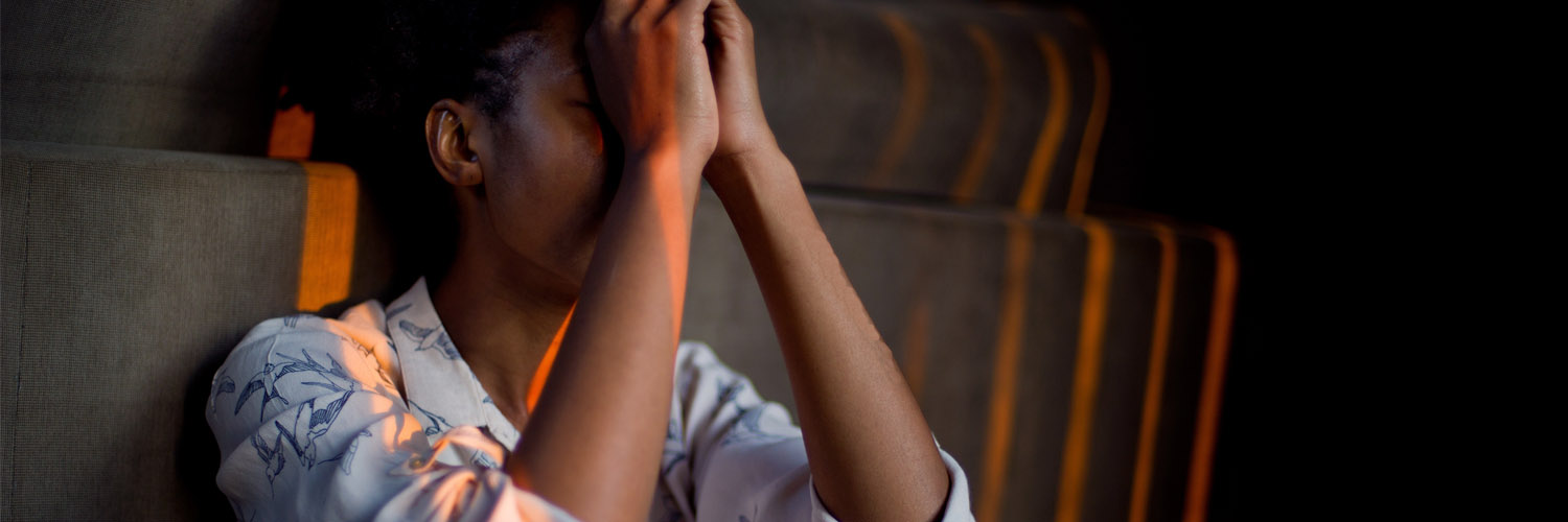 woman sitting against wall stressed