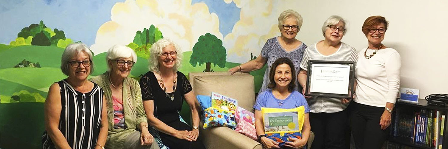group of children sitting on a couch reading together